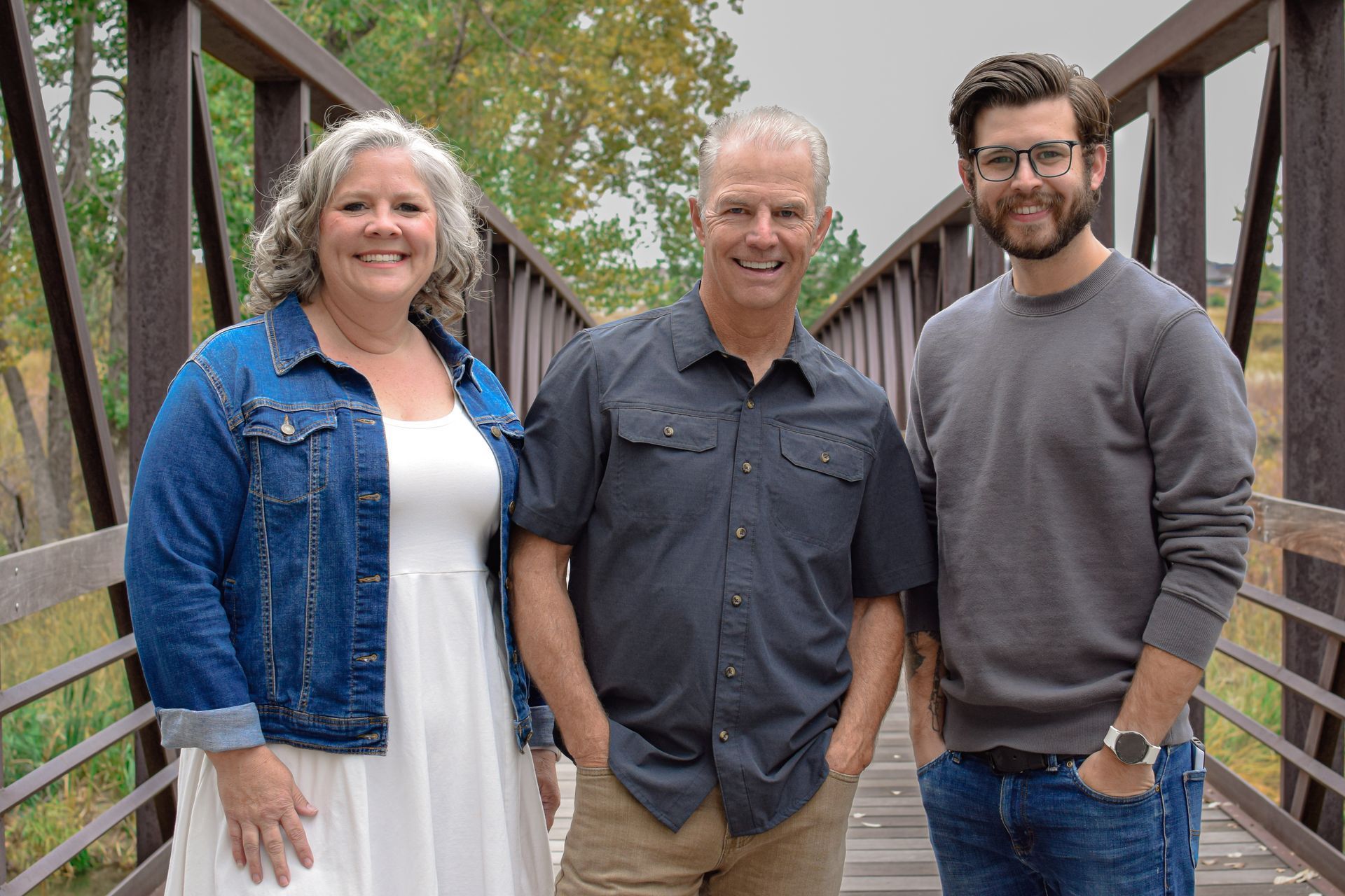 A family is posing for a picture on a bridge.