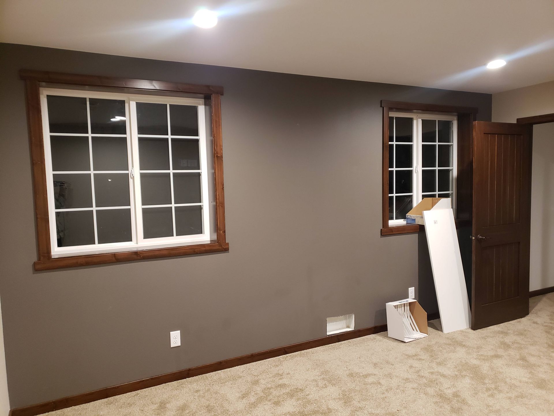 A room with two windows and a carpeted floor.