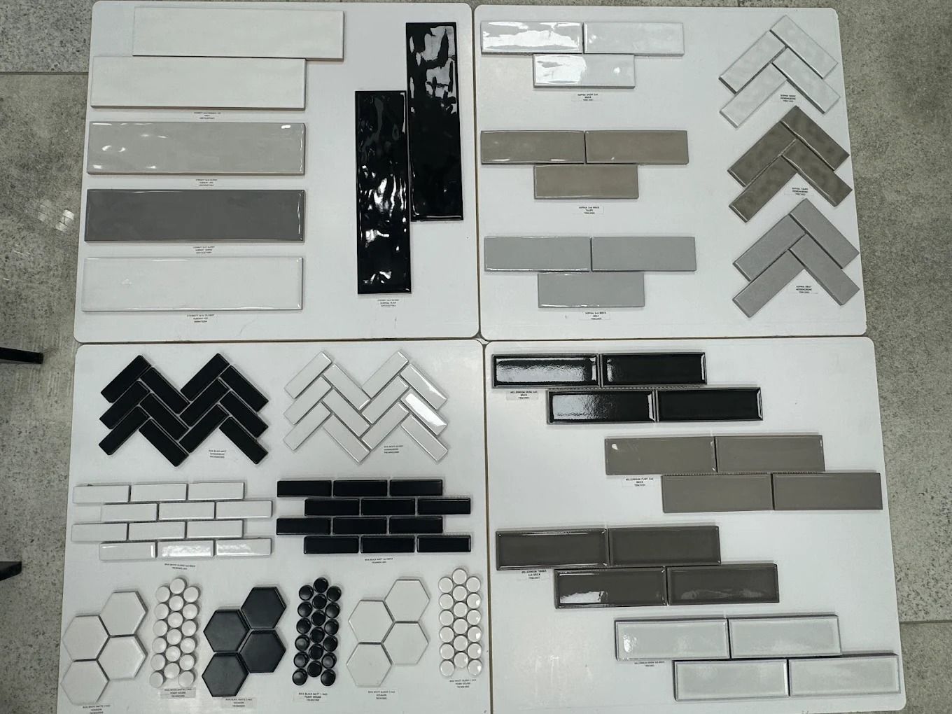 Sample board of gray, black, and white tile or brick patterns arranged in panels