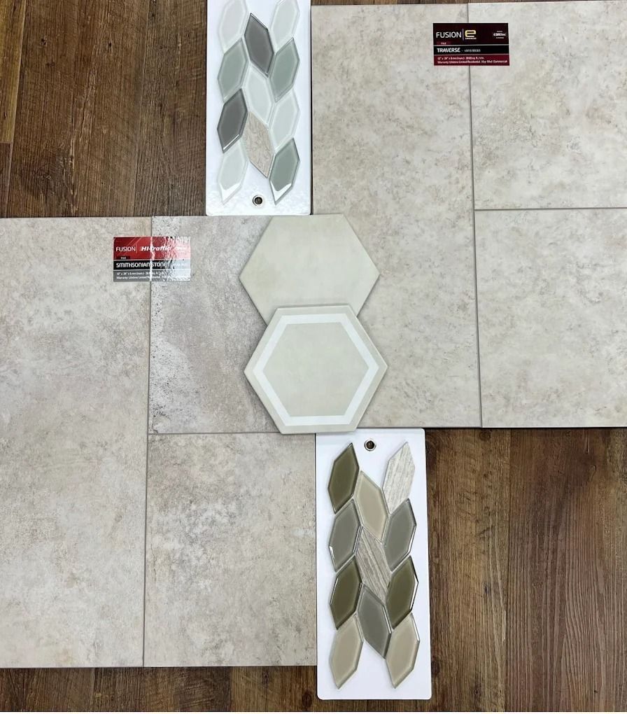 Assorted beige and gray decorative tile samples arranged on a wall display.