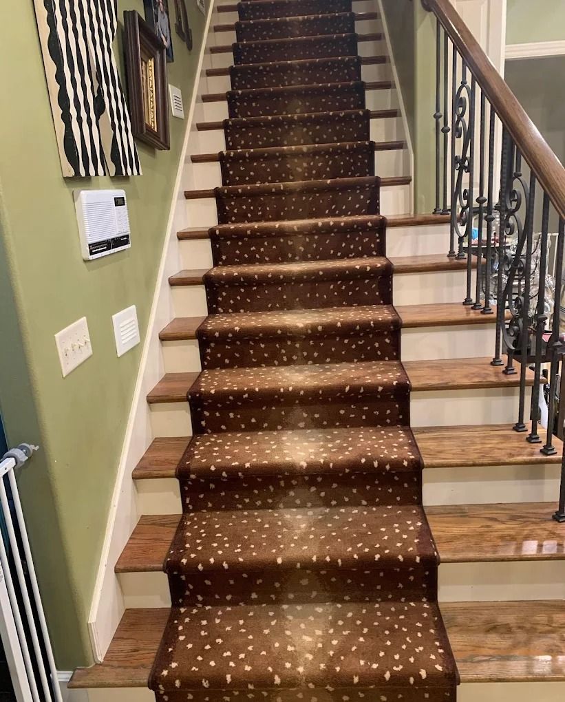 Carpeted staircase with wooden steps and black iron railing in a home interior