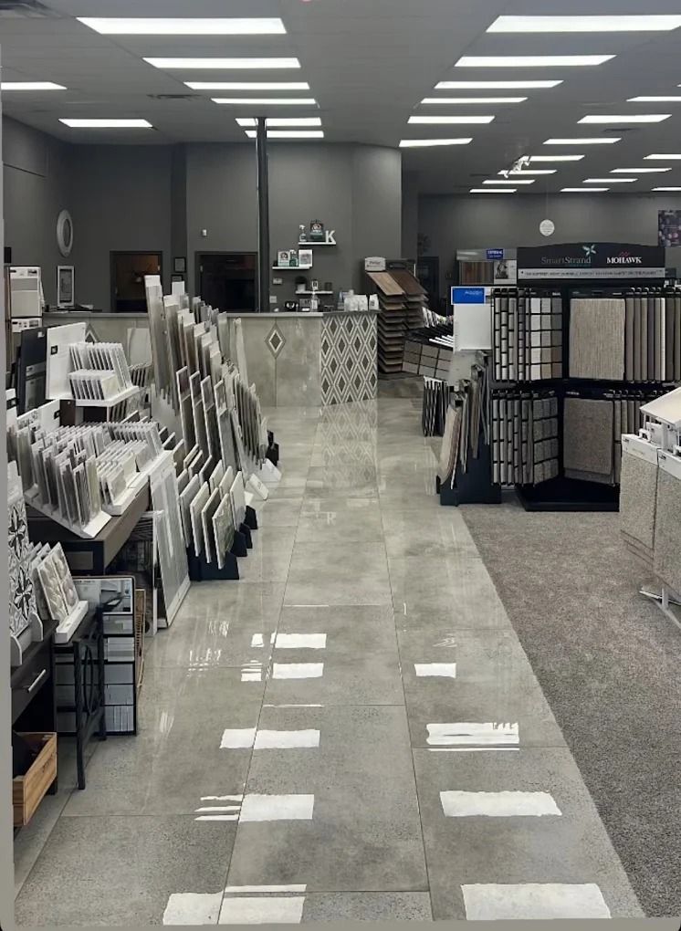 Wide retail store aisle with display racks, gray carpet, and bright ceiling lights