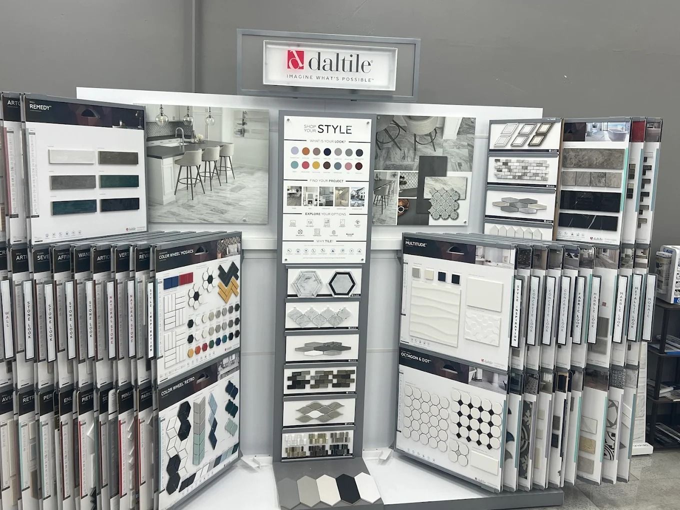 Tile showroom display with sample boards and racks of patterned tiles in a white showroom