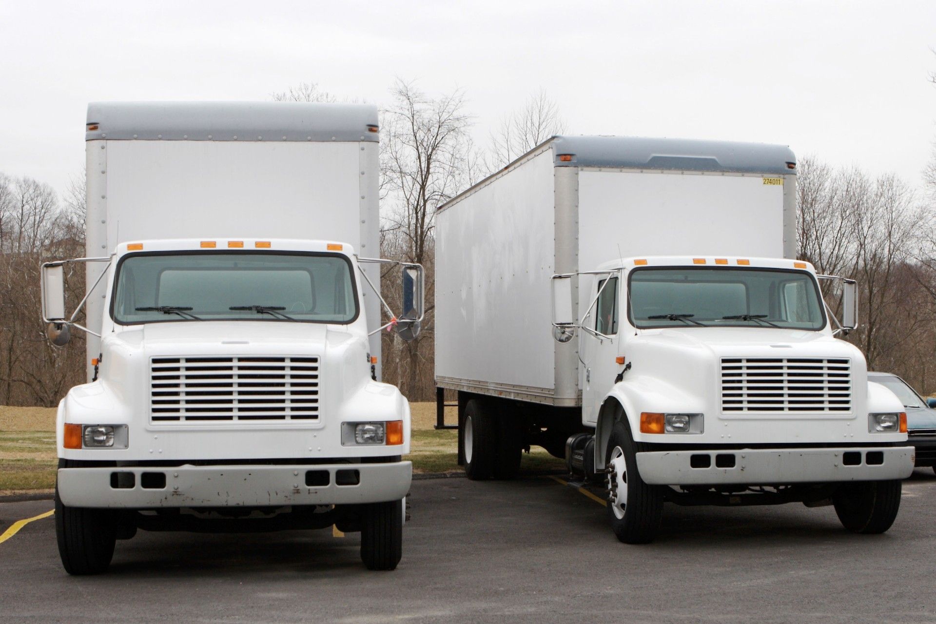 2 white moving trucks