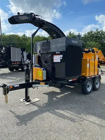 Black and yellow wood chipper on a trailer, ready for operation outdoors.