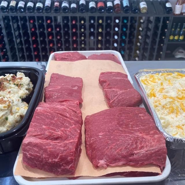 A tray of meat and a tray of mashed potatoes on a counter