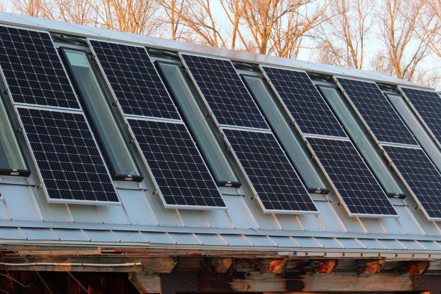Solar panels installed on a metal roof, alternating with skylights.