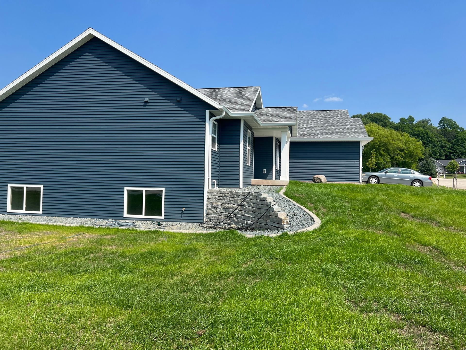 A large house is sitting on top of a lush green hill.