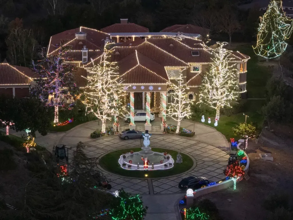 An aerial view of a house decorated with christmas lights