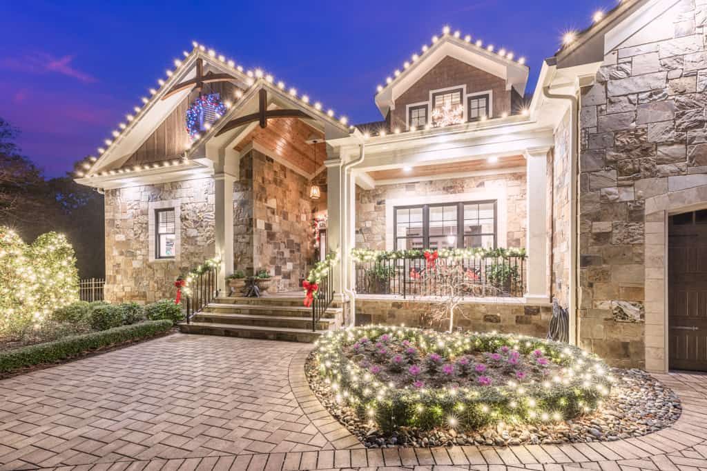 A large stone house decorated for christmas with christmas lights.