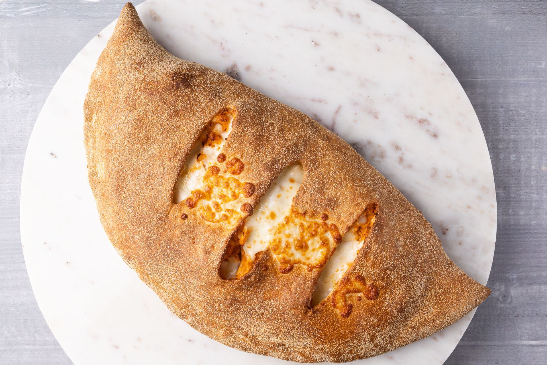 A close up of a calzone on a plate on a table.