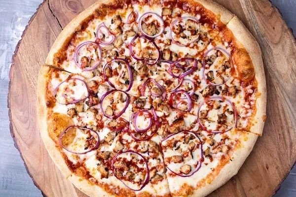 A pizza is sitting on a wooden cutting board.