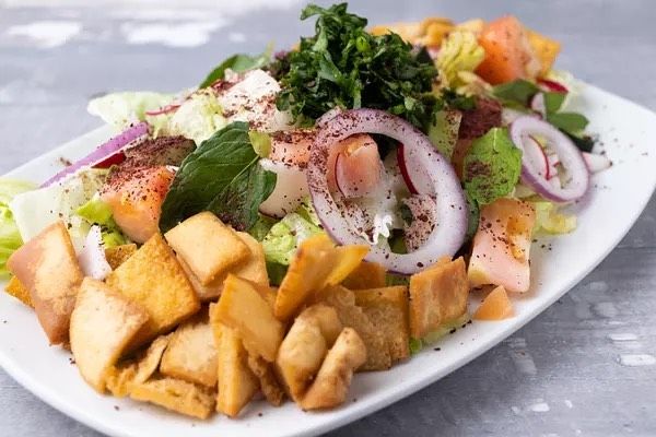 A white plate topped with a salad and fried food.