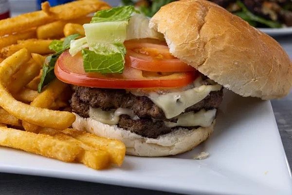 A hamburger and french fries on a white plate.