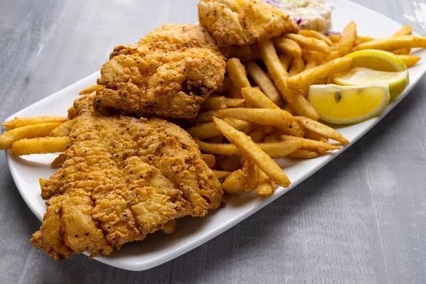 A white plate topped with fried fish and french fries.