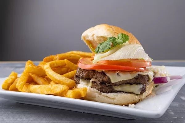 A hamburger and french fries on a white plate.