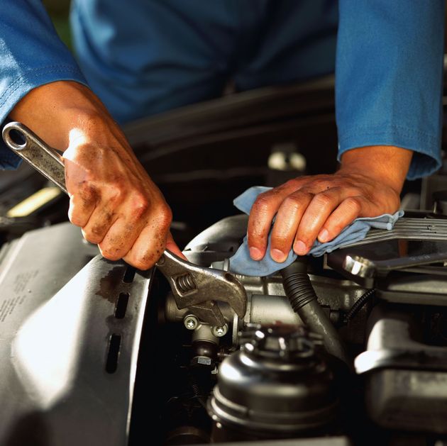 Mechanic using a wrench to repair car engine in a workshop
