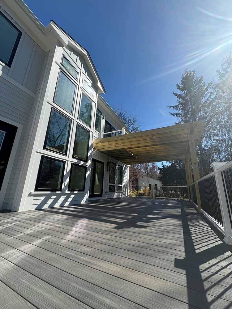 A large white house with a large deck in front of it.