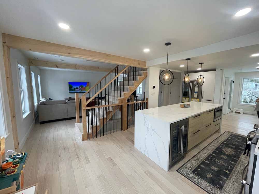 A kitchen with a large island and stairs leading up to the second floor.