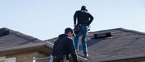 Two repair man inspecting roof damage