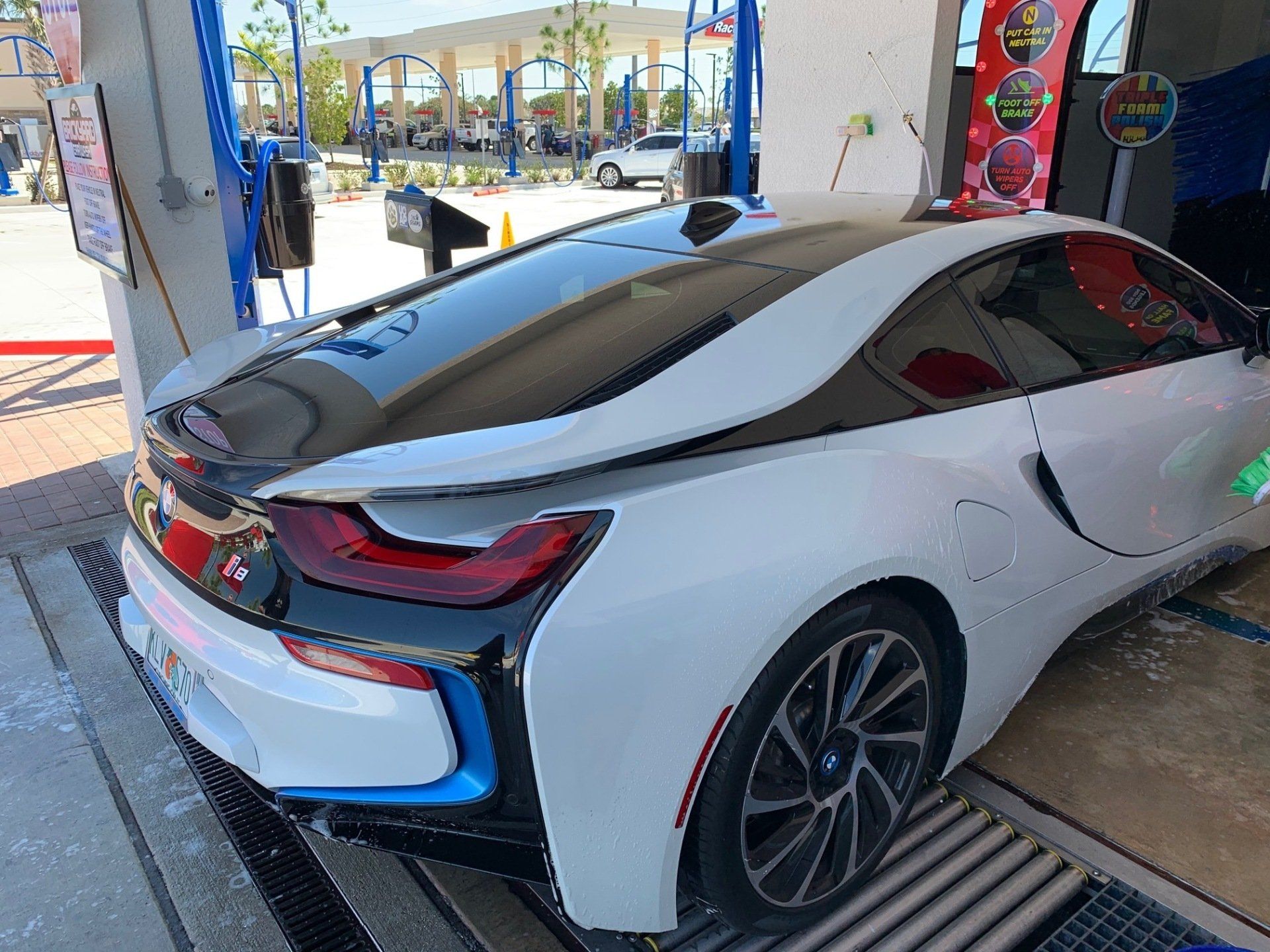 White BMW i8 being washed at a car wash.