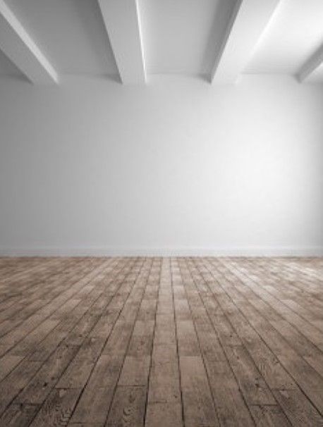 An empty room with a wooden floor and white walls.