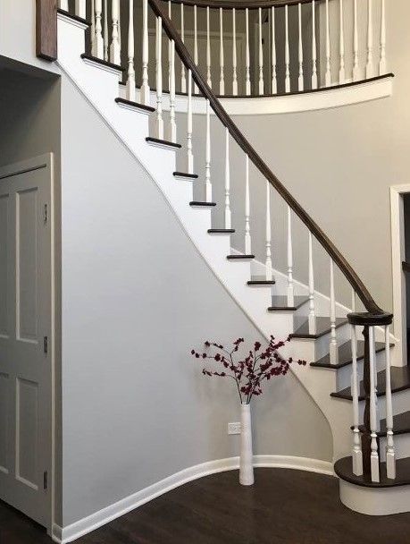 A staircase in a house with a vase of flowers on the bottom step