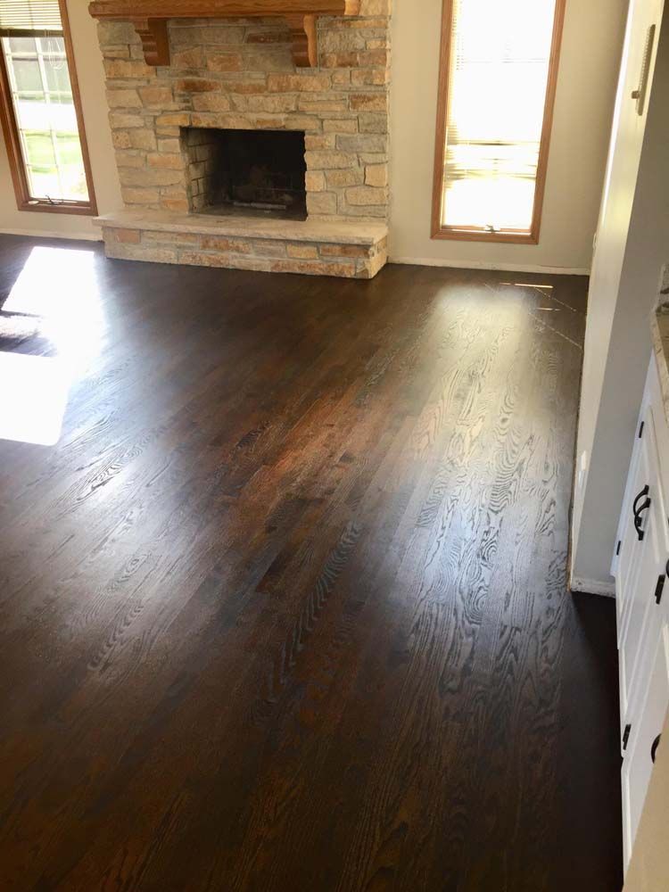 A living room with hardwood floors and a fireplace.