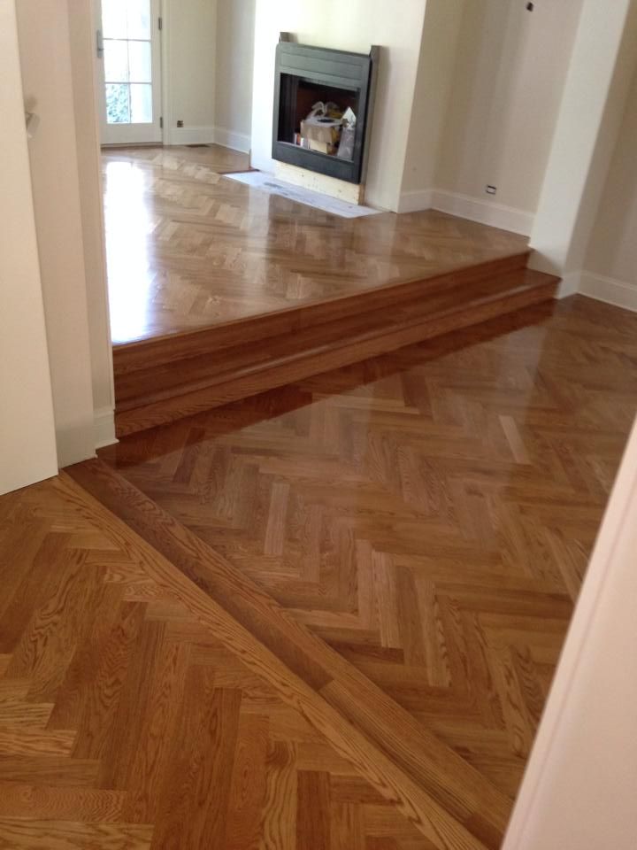A living room with a wooden floor and a fireplace.
