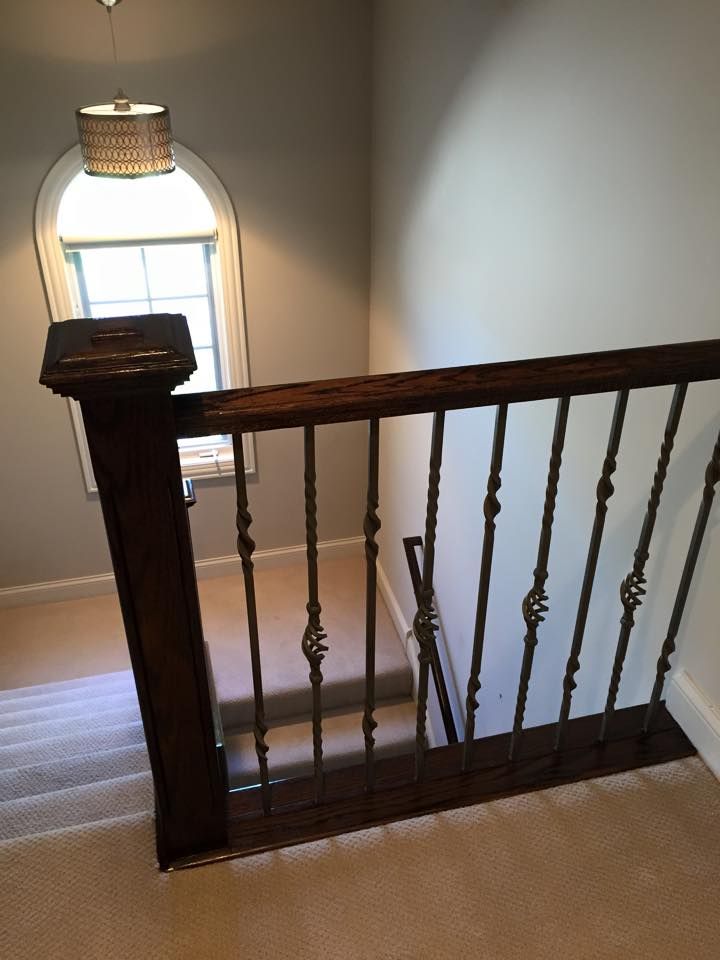A staircase with a wrought iron railing and a window.