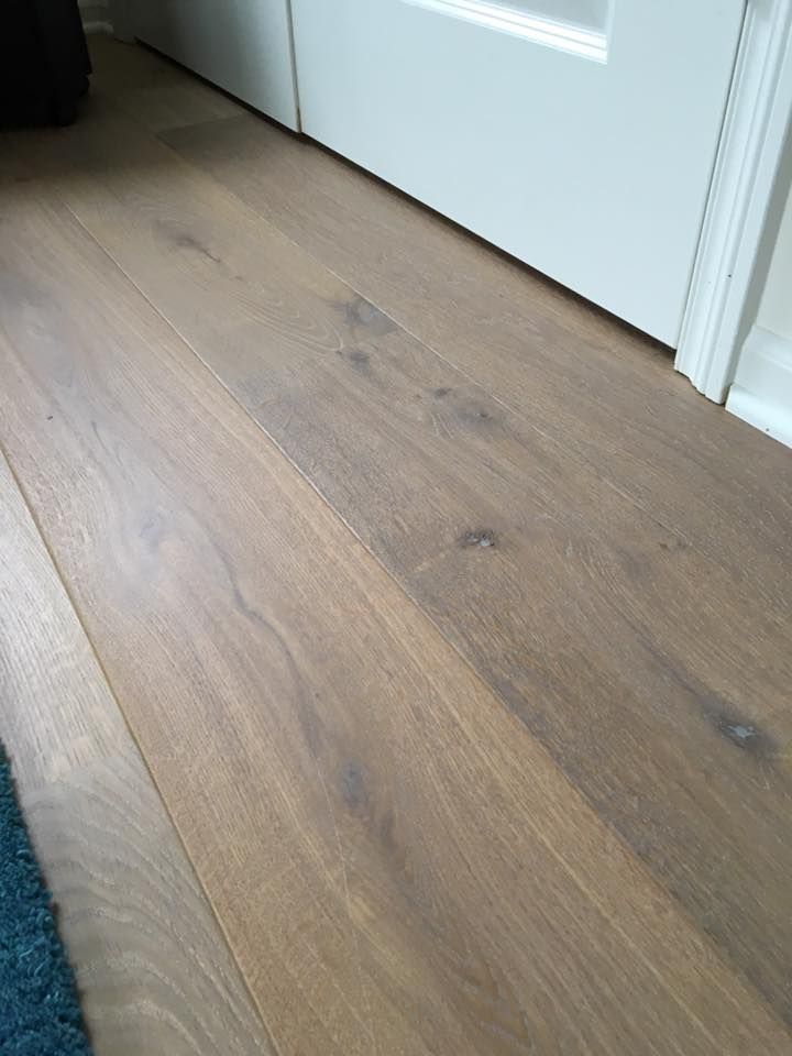 A close up of a wooden floor next to a door.