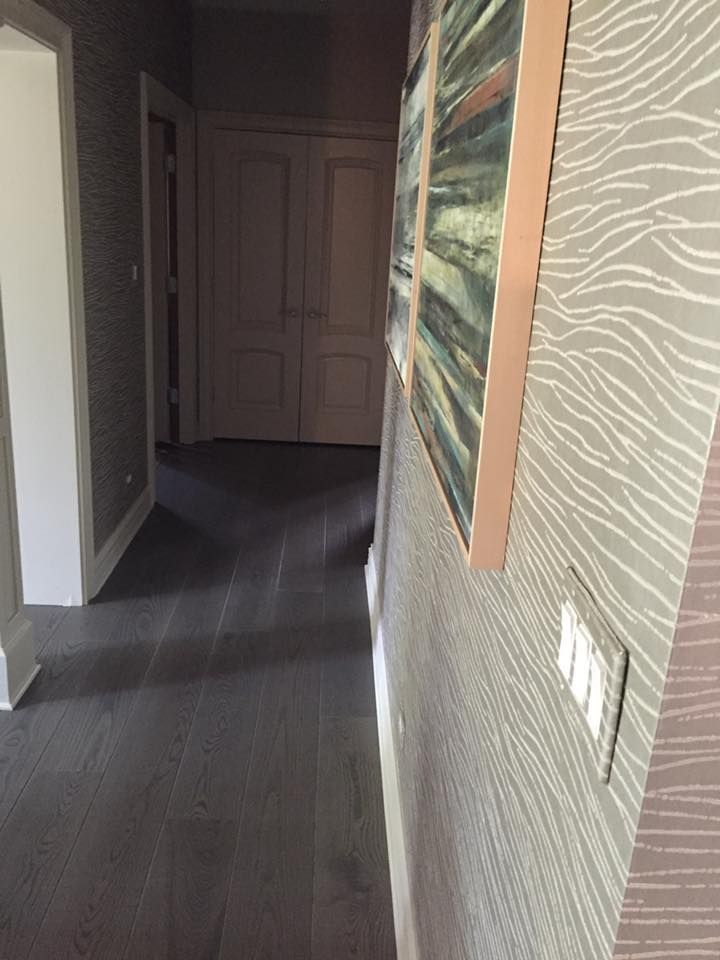 A hallway with a painting on the wall and a light switch.