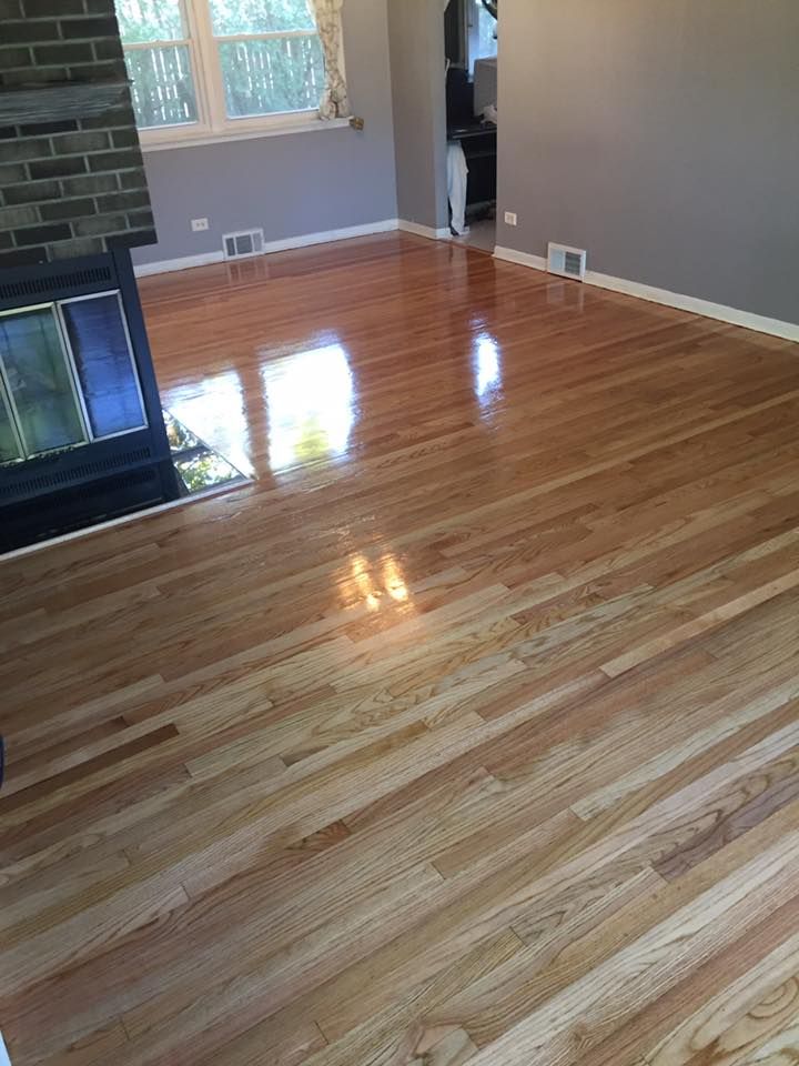 A living room with hardwood floors and a fireplace.