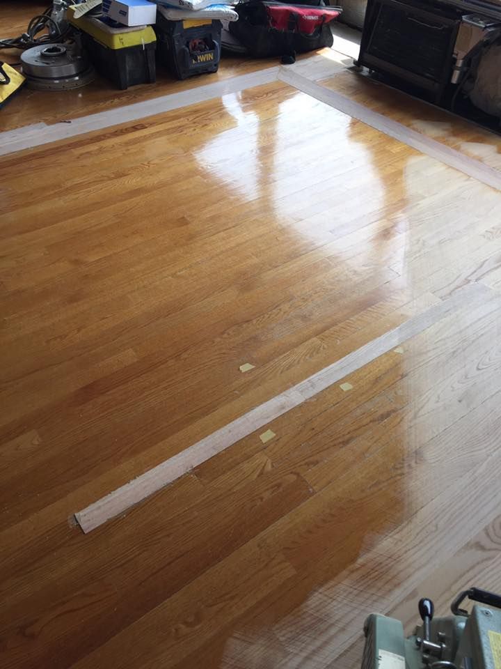 A wooden floor with a white line on it in a living room.
