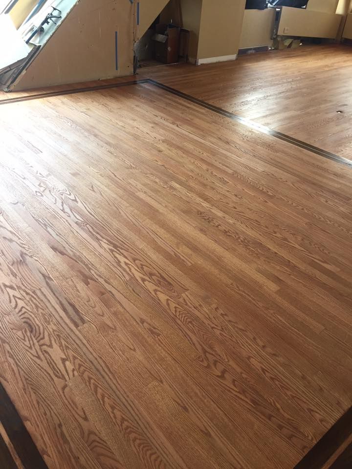 A wooden floor with a black border in a living room.