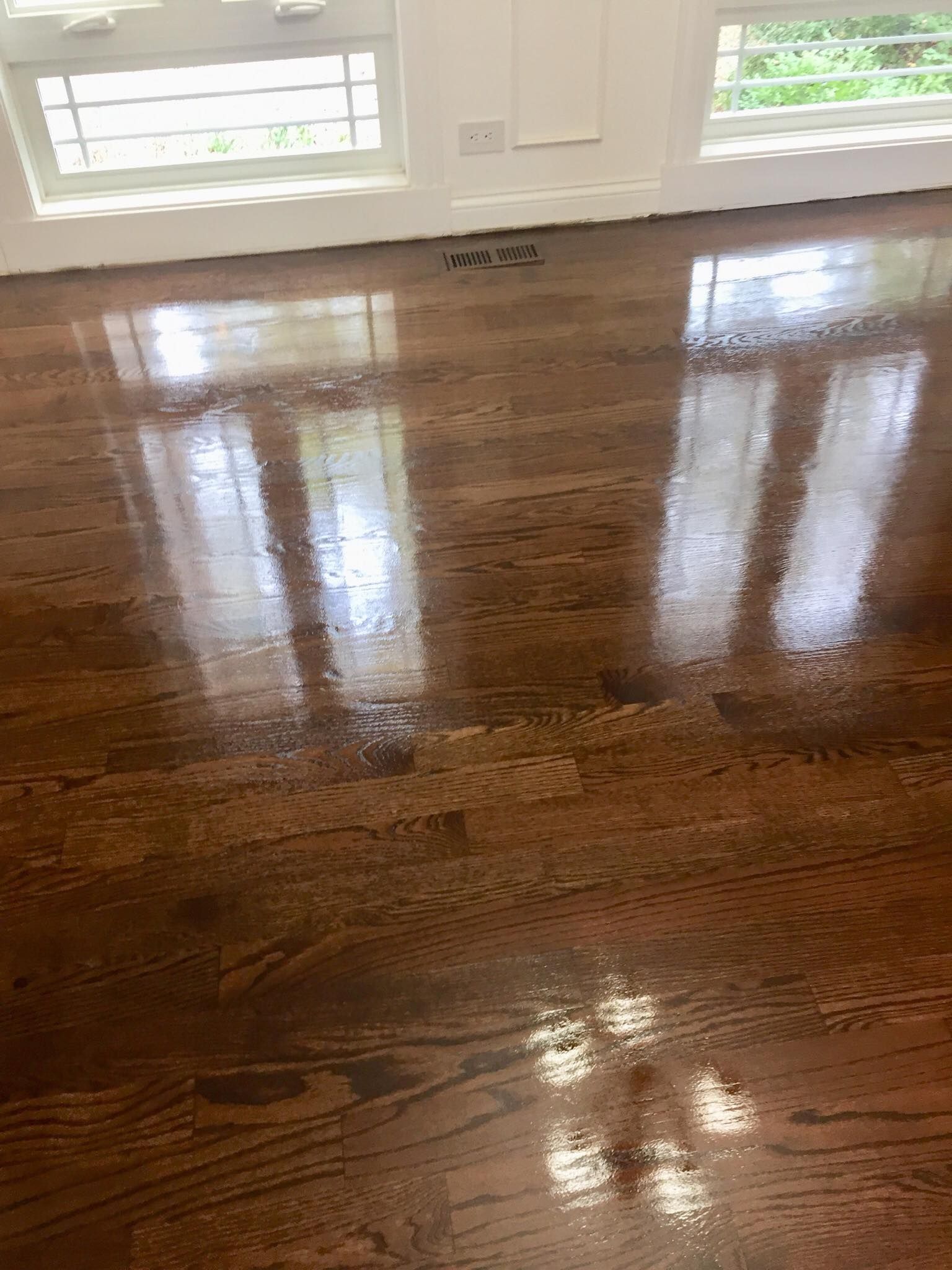 A close up of a wooden floor with a window in the background.