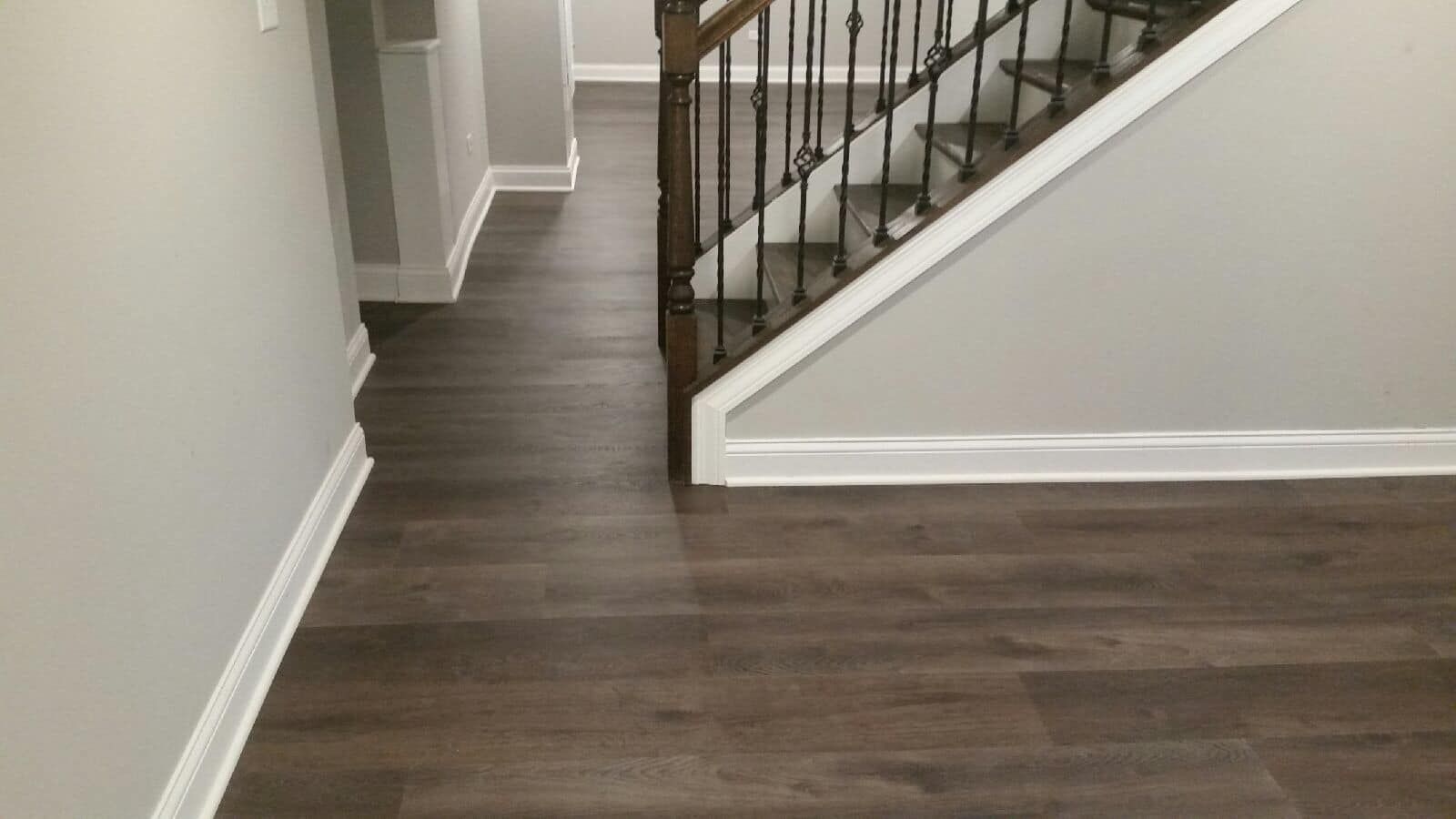 A hallway with hardwood floors and stairs in a house.