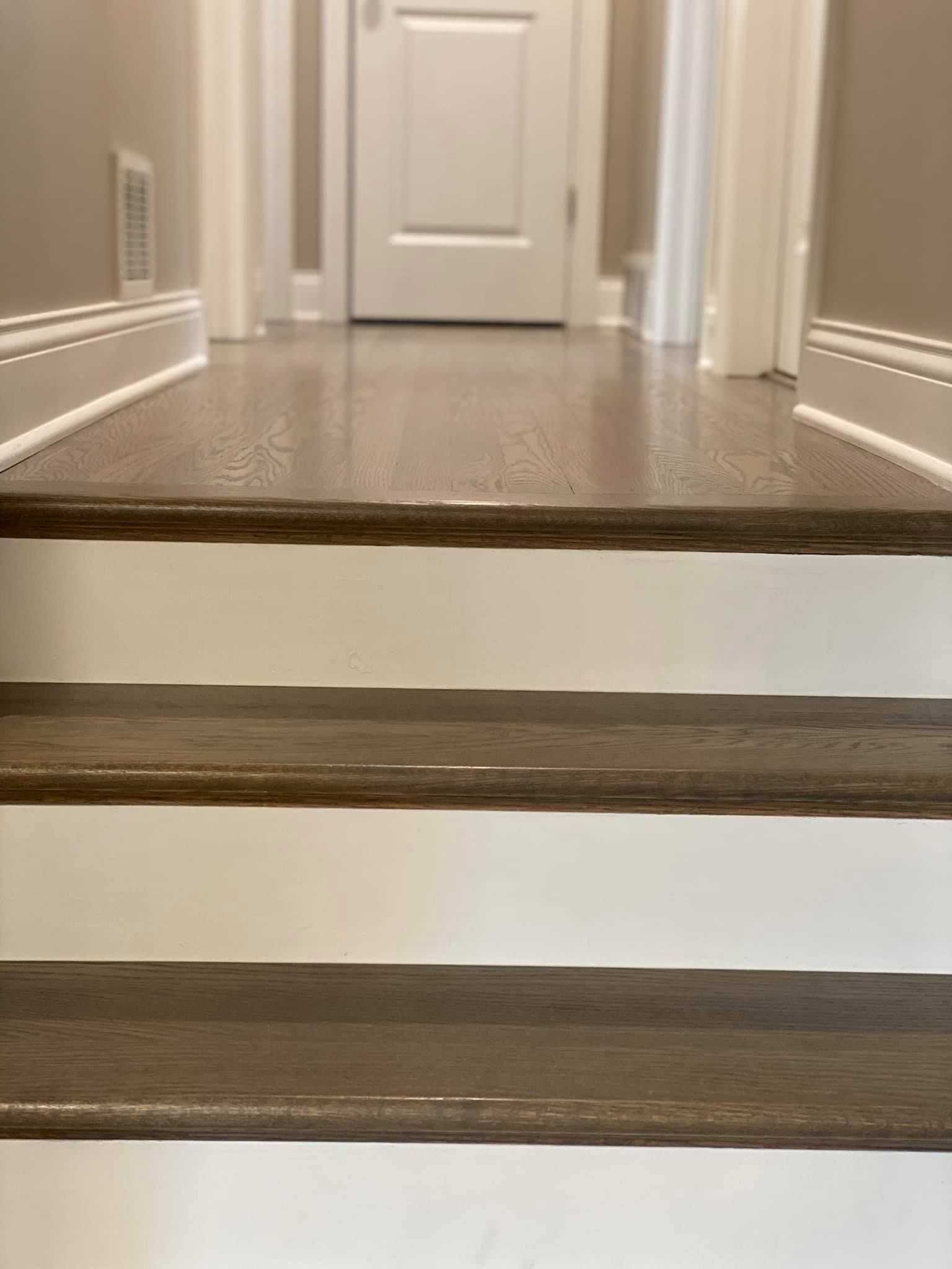 A close up of a set of stairs leading up to a door in a hallway.
