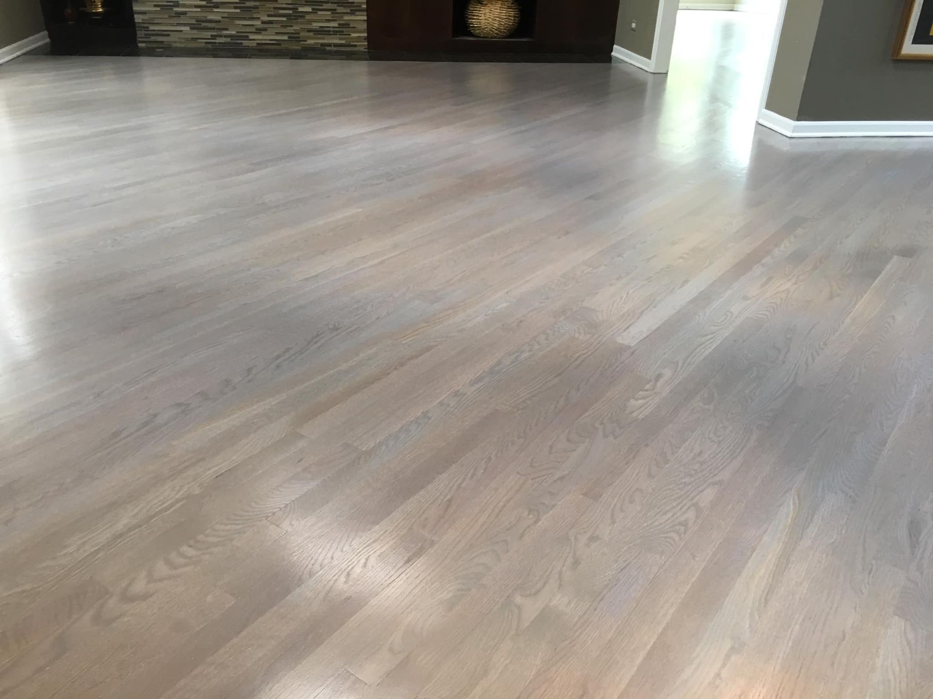 A living room with a hardwood floor and a fireplace.