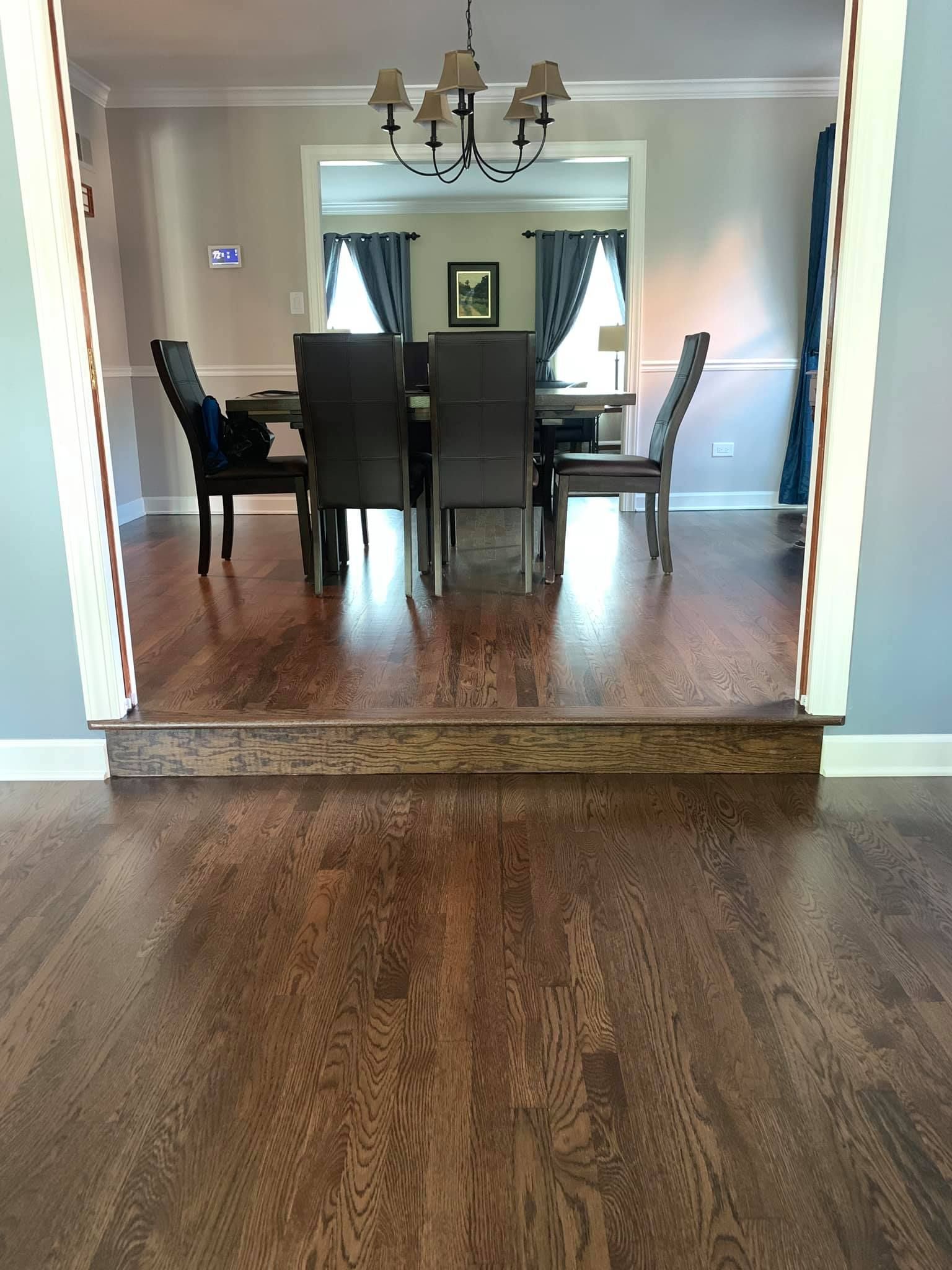 A dining room with a table and chairs and a chandelier.