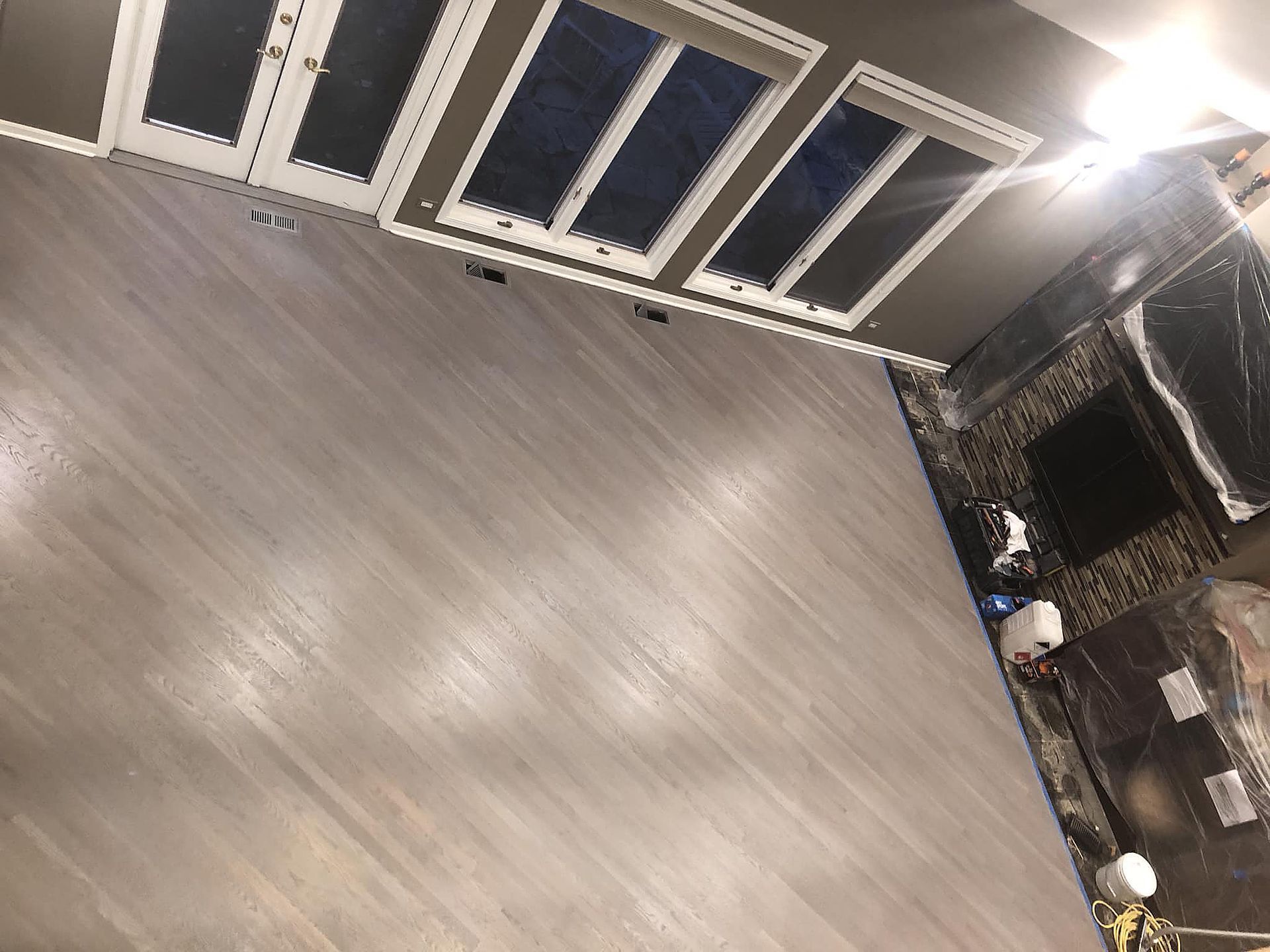 A room with a wooden floor and a fireplace.