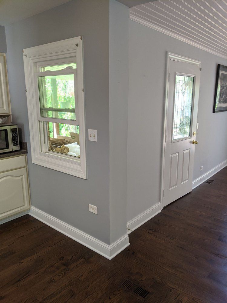 A kitchen with a window and a door in the corner.