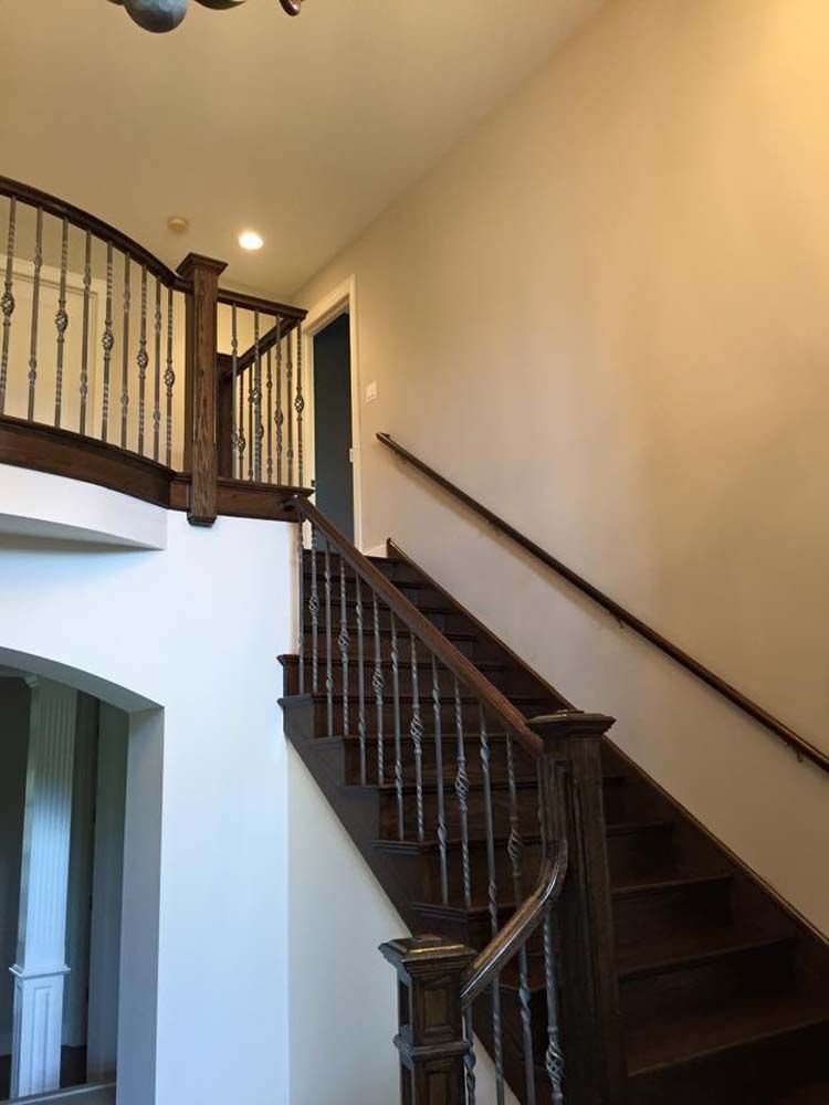 A wooden staircase with a metal railing in a house.
