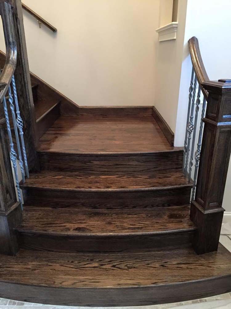 A wooden staircase with a metal railing in a house.