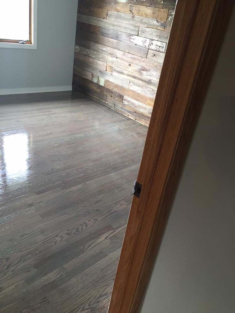 A room with hardwood floors and a wooden wall.