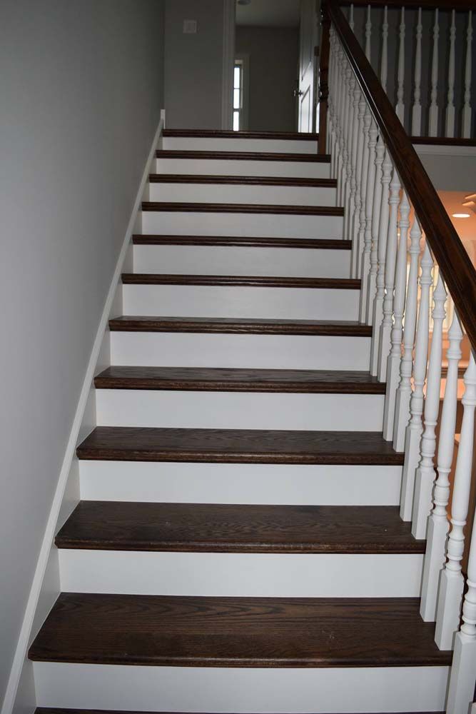 A set of stairs with wooden steps and a white railing.
