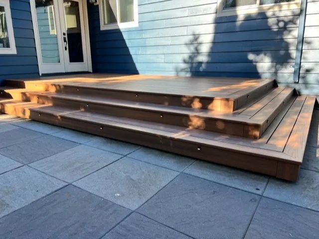 A blue house with a wooden deck and stairs