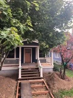 A house with a porch and stairs is being built.