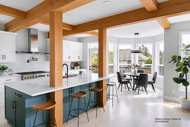 A kitchen with a large island and wooden beams.