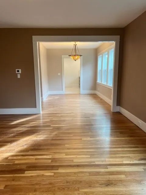 An empty room with hardwood floors and brown walls